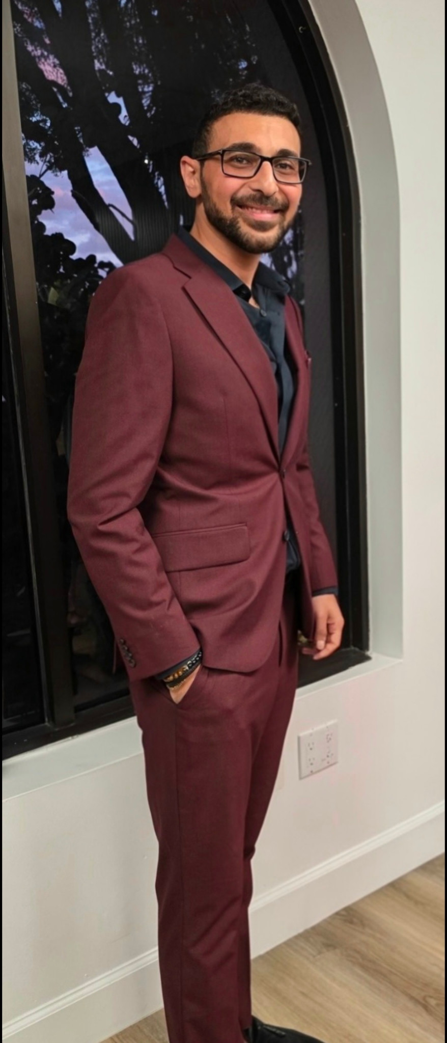 Mina Tawadros in a burgundy suit